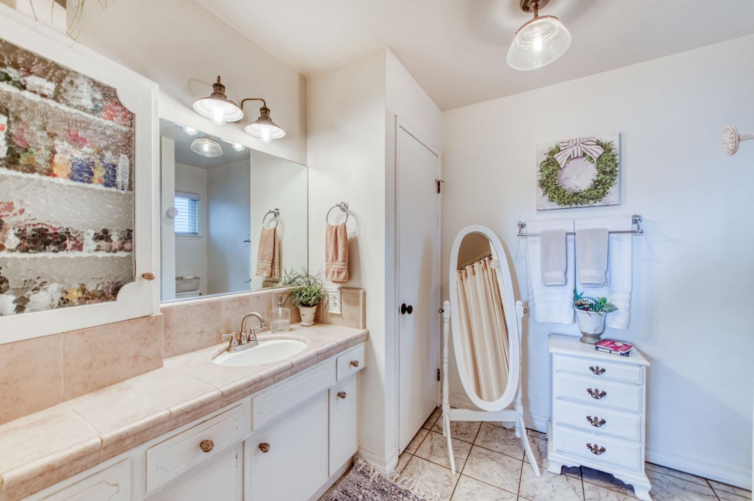 1880 East Cardella Street Firebaugh, CA 93622 - Photo 25 of 42 a bathroom with a sink a vanity and a mirror