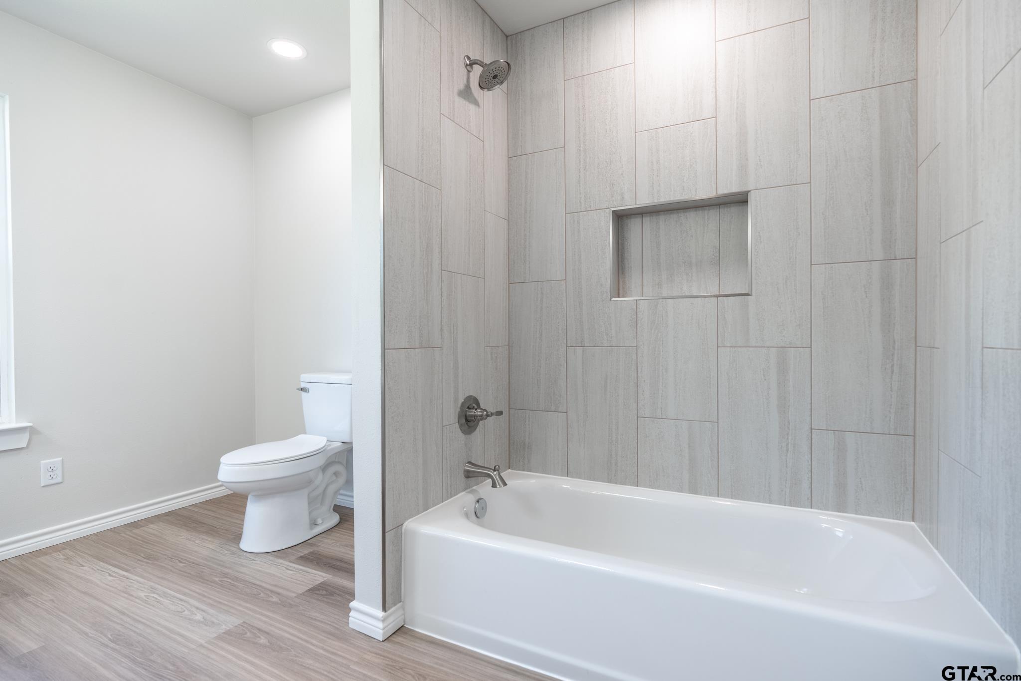 233 Harrison Street Longview, TX 75601 - Photo 30 of 44 a bathroom with a toilet and a bathtub