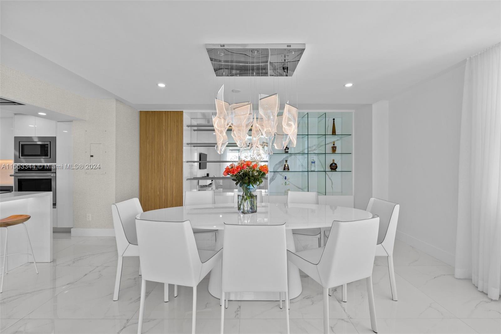 5151 Collins Avenue, Unit 1527 Miami Beach, FL 33140 - Photo 13 of 65 a view of a dining room with furniture and chandelier