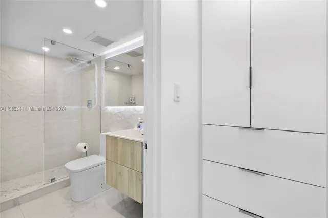 a bathroom with a sink toilet a mirror and shower