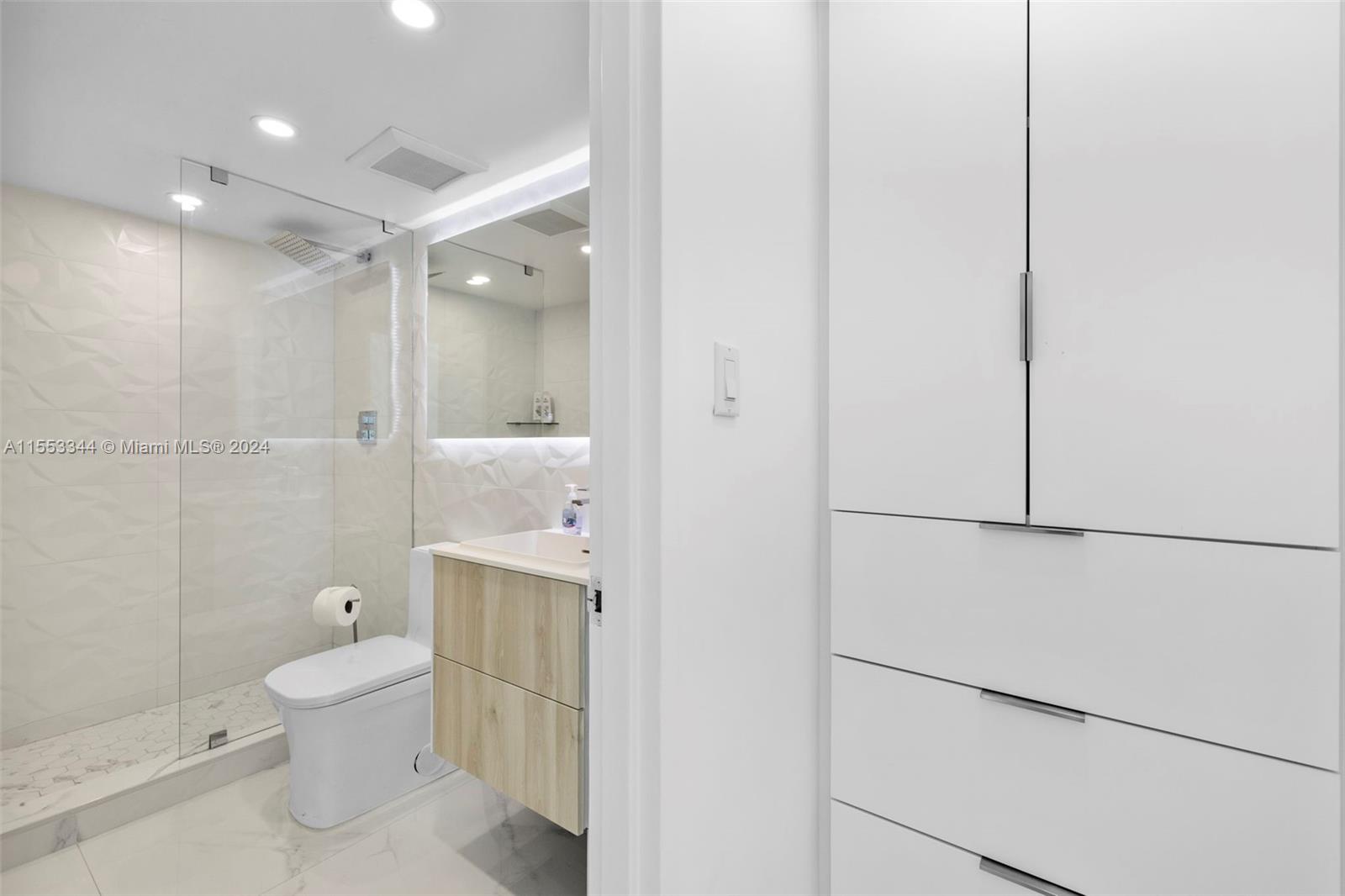 5151 Collins Avenue, Unit 1527 Miami Beach, FL 33140 - Photo 30 of 65 a bathroom with a toilet a sink and shower