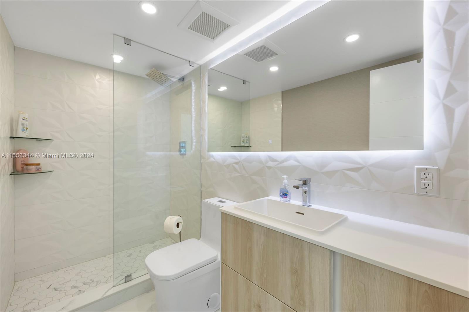 5151 Collins Avenue, Unit 1527 Miami Beach, FL 33140 - Photo 31 of 65 a bathroom with a sink a toilet and shower