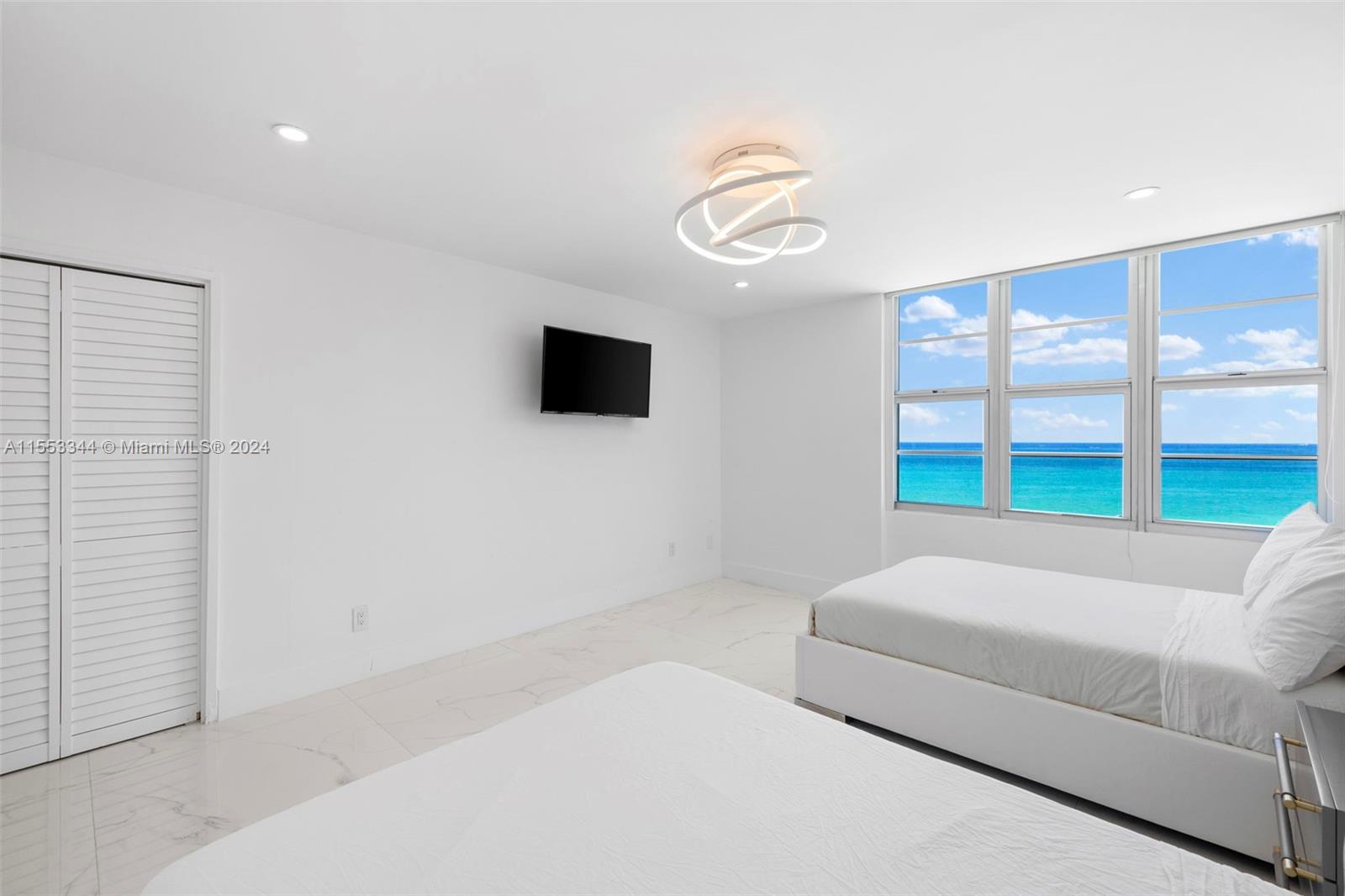 5151 Collins Avenue, Unit 1527 Miami Beach, FL 33140 - Photo 33 of 65 a bedroom with a bed and a flat screen tv