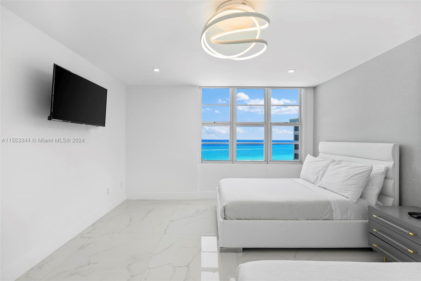 5151 Collins Avenue, Unit 1527 Miami Beach, FL 33140 - Photo 34 of 65 a living room with furniture and a flat screen tv