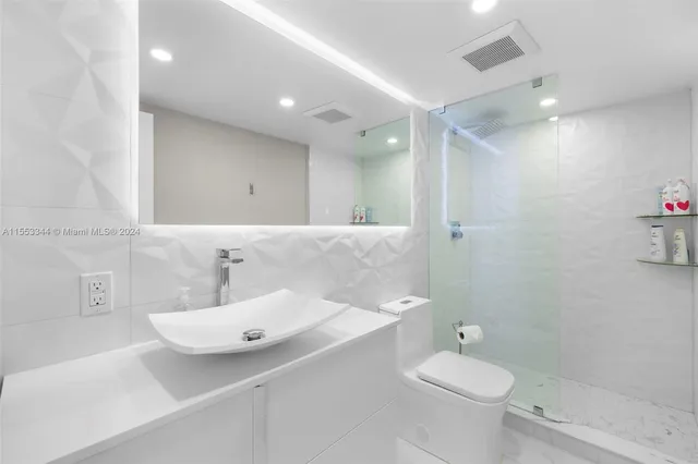 a bathroom with a shower a toilet and a sink