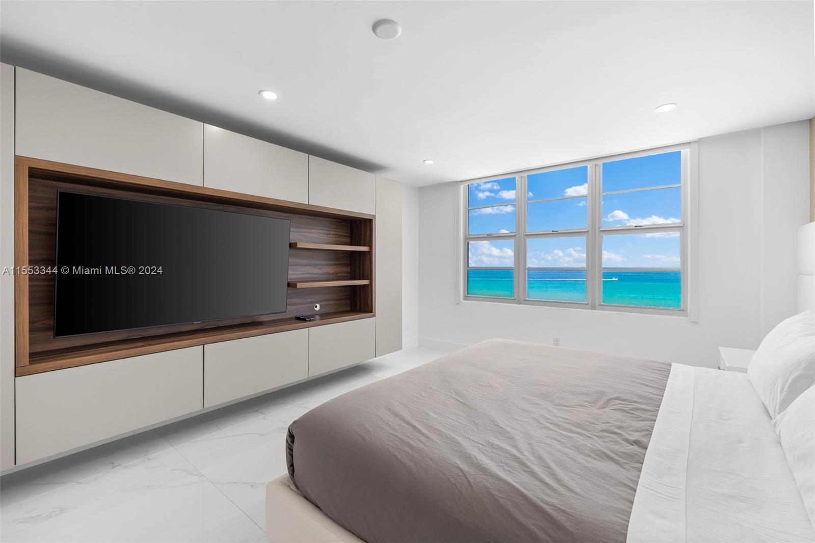 5151 Collins Avenue, Unit 1527 Miami Beach, FL 33140 - Photo 38 of 65 a room with a bed and a television