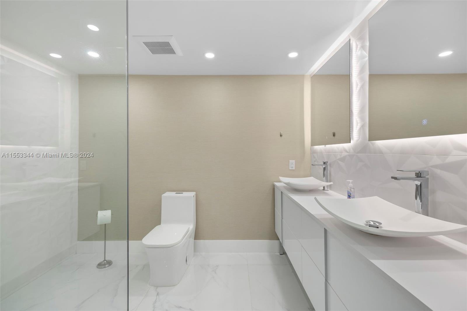 5151 Collins Avenue, Unit 1527 Miami Beach, FL 33140 - Photo 41 of 65 a bathroom with a toilet sink and mirror