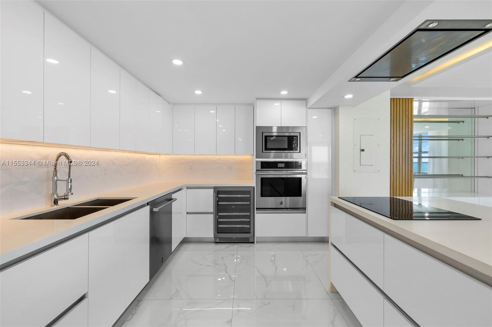 5151 Collins Avenue, Unit 1527 Miami Beach, FL 33140 - Photo 5 of 65 a kitchen with granite countertop a sink and stainless steel appliances