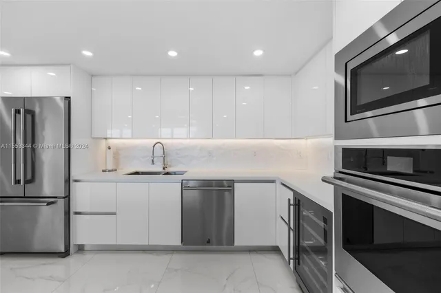a kitchen with a refrigerator a stove and a sink