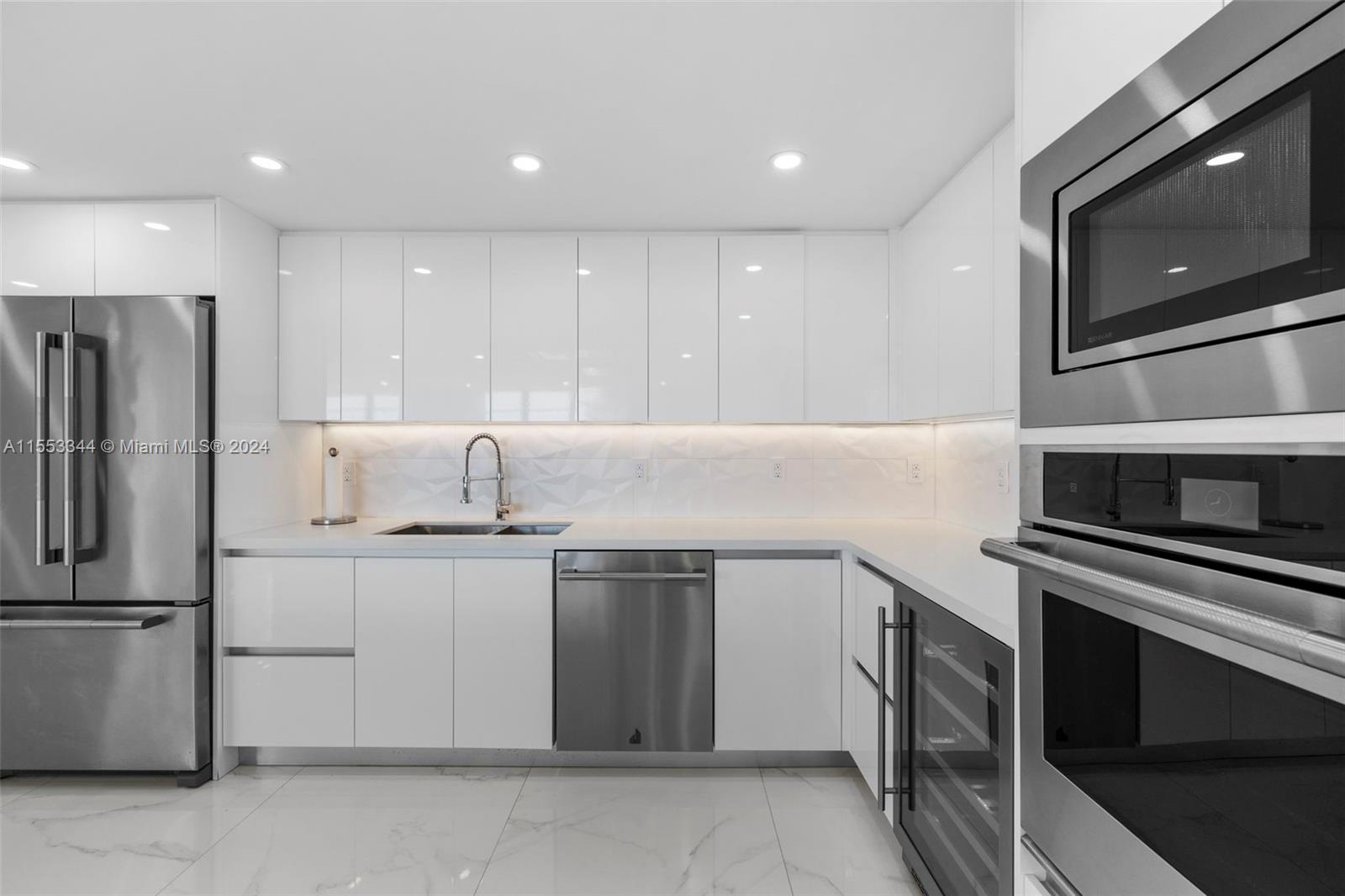5151 Collins Avenue, Unit 1527 Miami Beach, FL 33140 - Photo 6 of 65 a kitchen with stainless steel appliances a stove microwave and refrigerator