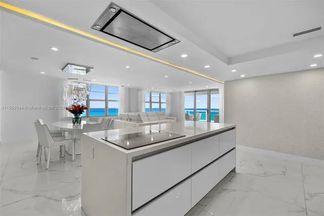 a large kitchen with stainless steel appliances granite countertop a sink a stove and a refrigerator