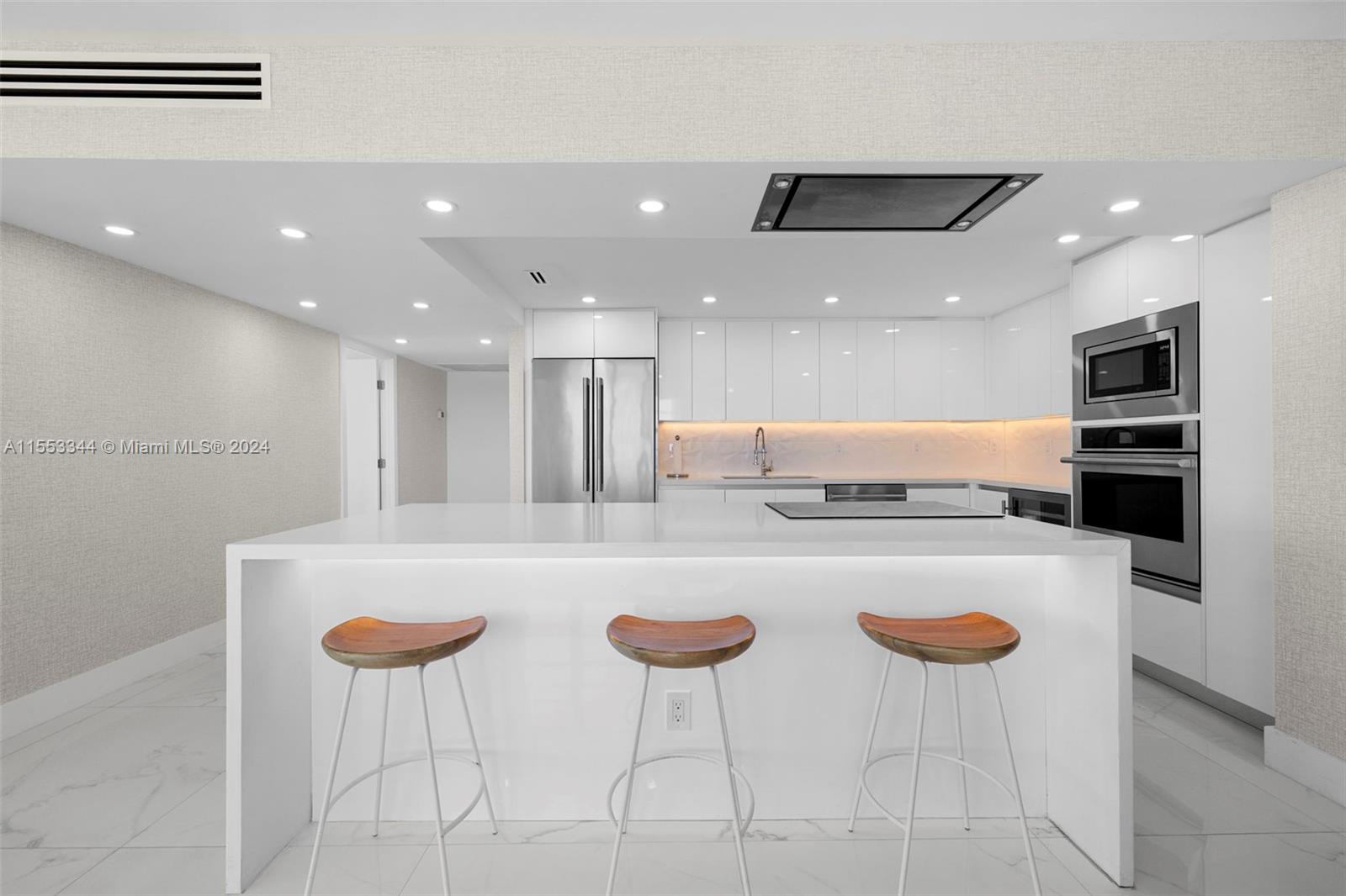 5151 Collins Avenue, Unit 1527 Miami Beach, FL 33140 - Photo 10 of 65 a kitchen with a dining table and chairs