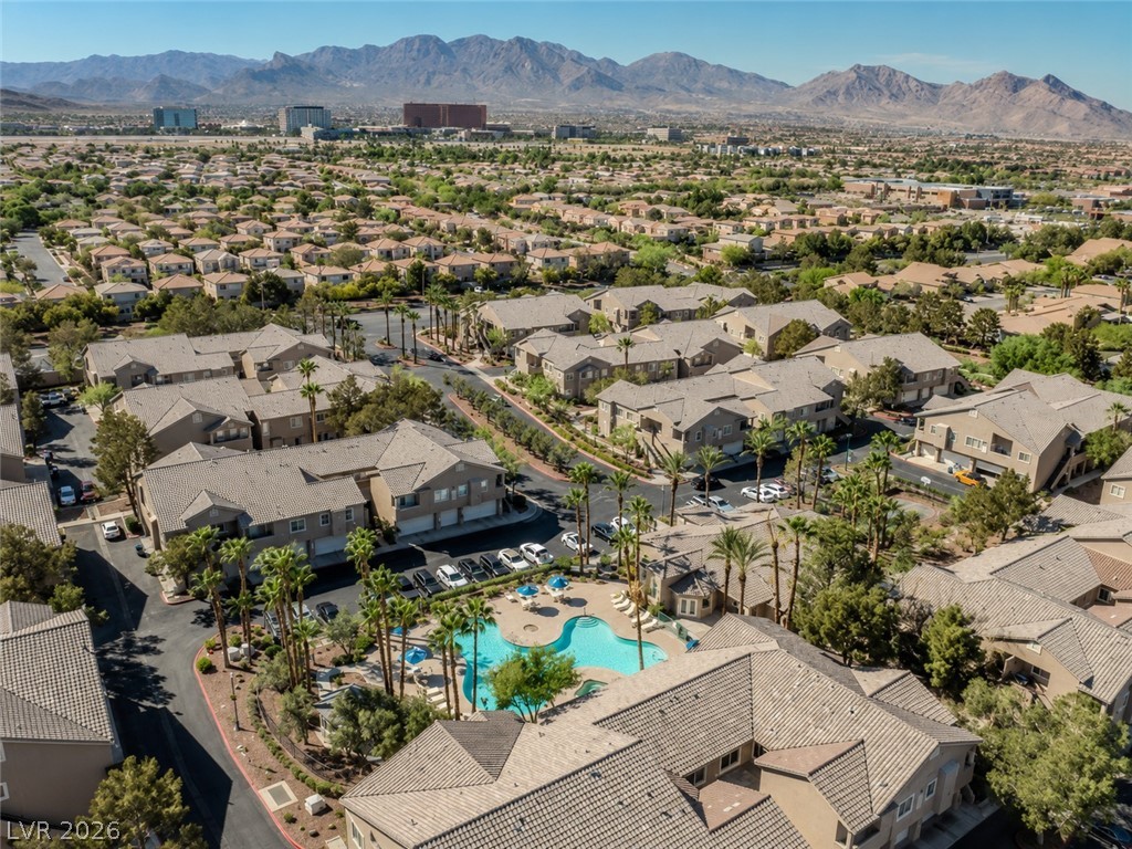 2153 Quarry Ridge Street, Unit 103 Las Vegas, NV 89117 - Photo 36 of 42 An aerial perspective reveals a vibrant community with inviting pool areas, set against a majestic mountain backdrop.