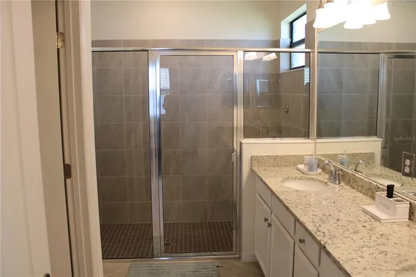 a bathroom with a granite countertop sink and mirror