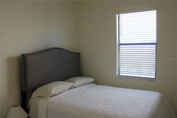a bedroom with a bed window and a window