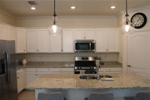 a kitchen with stainless steel appliances granite countertop a sink a stove a microwave and cabinets