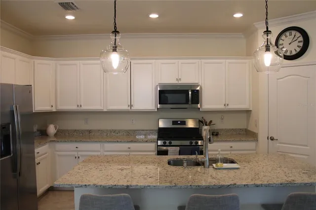 a kitchen with stainless steel appliances granite countertop a sink a stove a microwave and cabinets