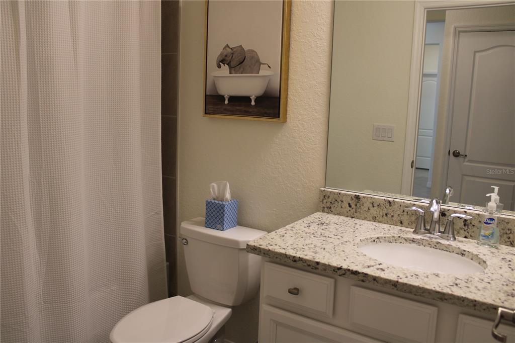 6647 Clairborne Lane Bradenton, FL 34211 - Photo 24 of 39 a bathroom with a granite countertop toilet sink and mirror