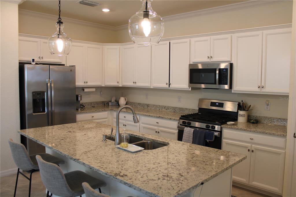 6647 Clairborne Lane Bradenton, FL 34211 - Photo 3 of 39 a kitchen with kitchen island granite countertop a sink a counter top space appliances and cabinets