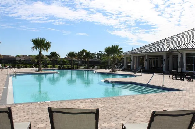 a view of a swimming pool with outdoor seating