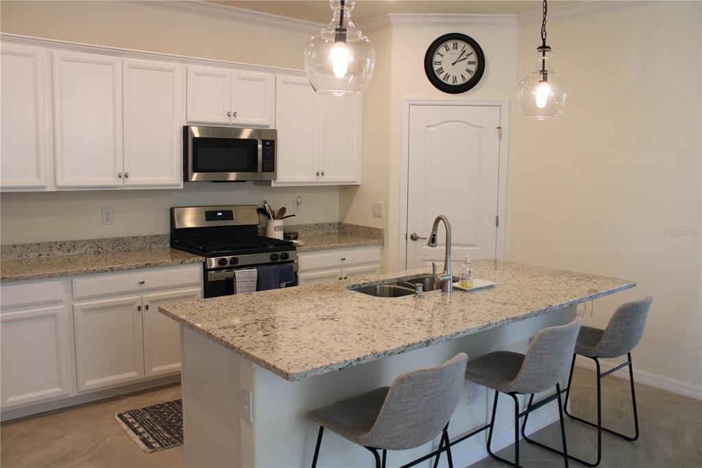 6647 Clairborne Lane Bradenton, FL 34211 - Photo 4 of 39 a kitchen with granite countertop a sink cabinets and stainless steel appliances