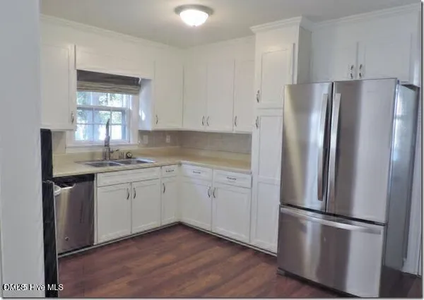 a kitchen with stainless steel appliances granite countertop a refrigerator sink and white cabinets