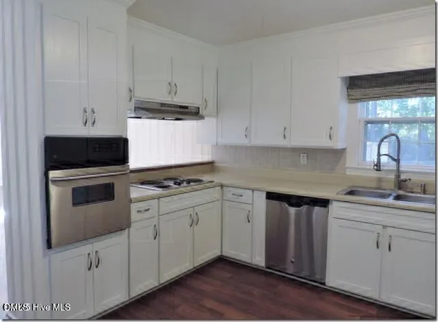 a kitchen with granite countertop white cabinets and white appliances