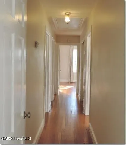 a view of a hallway with wooden floor