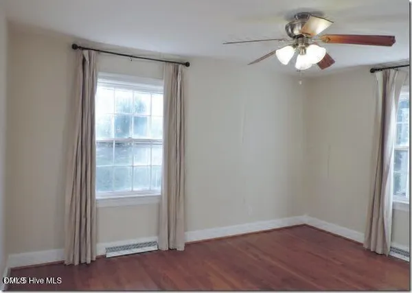 a view of a small space with wooden floor fan and window