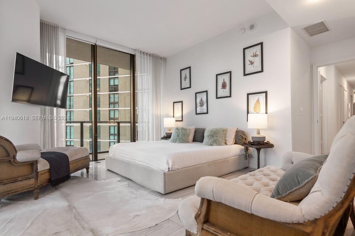 480 Northeast 31st Street, Unit 2307 Miami, FL 33137 - Photo 16 of 47 a bedroom with two beds and a flat screen tv