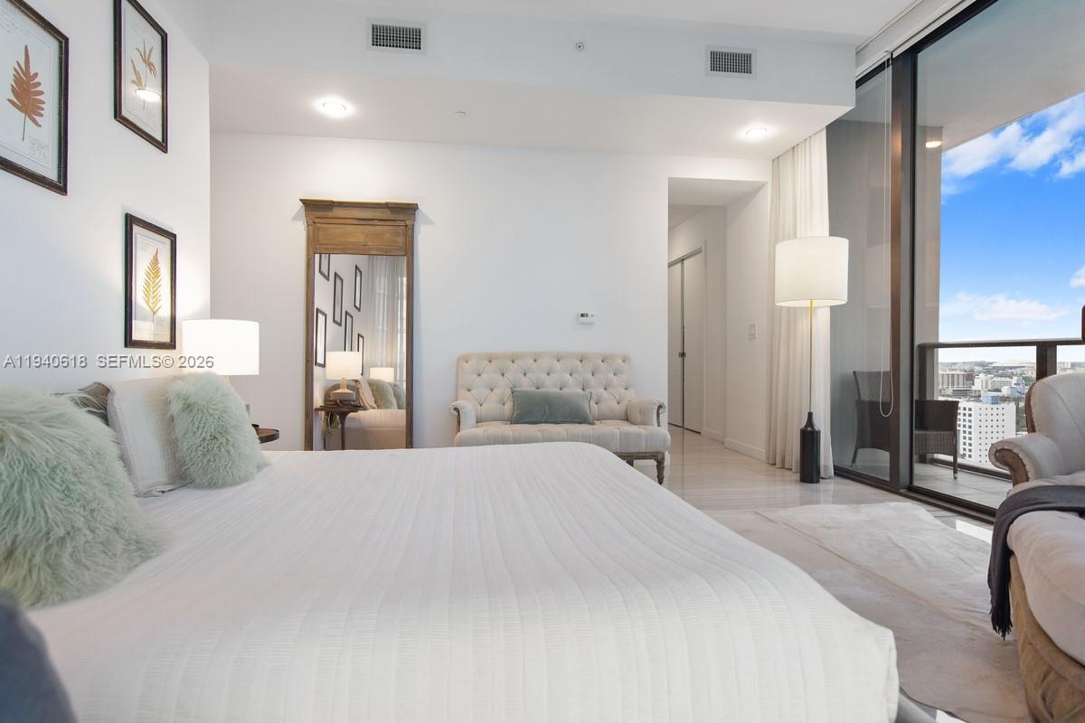 480 Northeast 31st Street, Unit 2307 Miami, FL 33137 - Photo 17 of 47 a bedroom with a large bed and a large mirror
