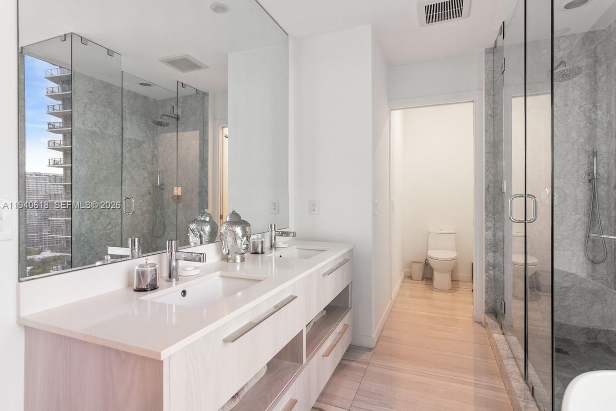 480 Northeast 31st Street, Unit 2307 Miami, FL 33137 - Photo 20 of 47 a bathroom with double vanity sinks and a mirror