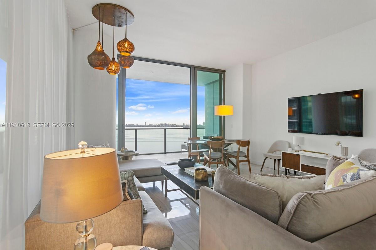 480 Northeast 31st Street, Unit 2307 Miami, FL 33137 - Photo 4 of 47 a living room with furniture and a flat screen tv