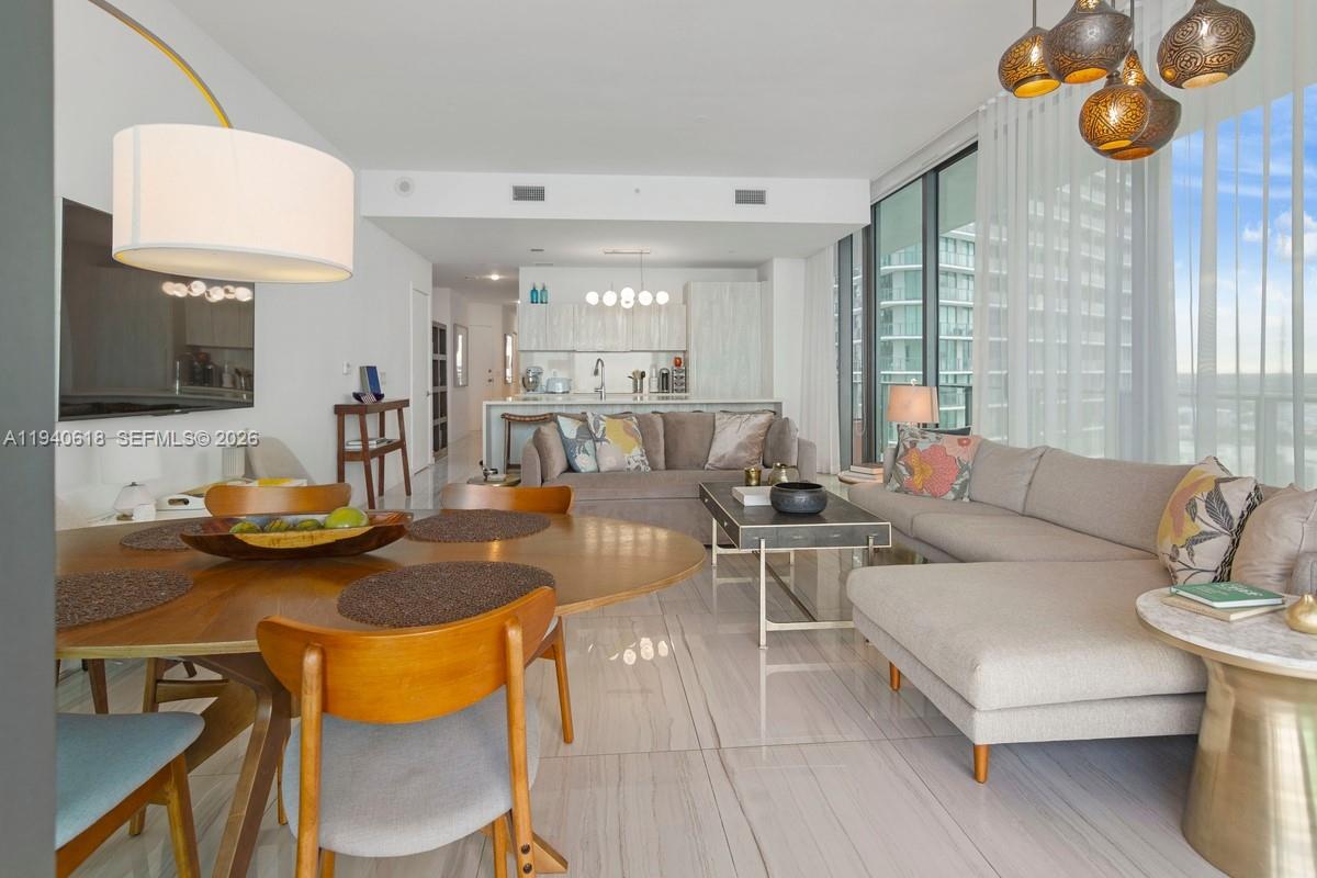 480 Northeast 31st Street, Unit 2307 Miami, FL 33137 - Photo 5 of 47 a living room with furniture and a flat screen tv