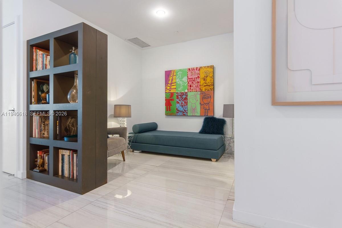 480 Northeast 31st Street, Unit 2307 Miami, FL 33137 - Photo 7 of 47 a living room with furniture and a book shelf