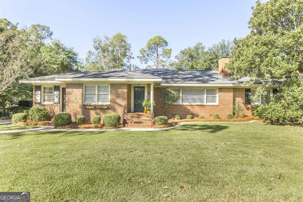 a front view of house with yard and green space