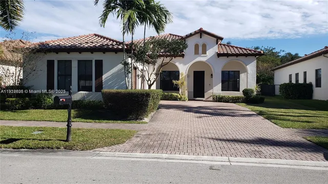 a front view of a house with a yard and potted plants