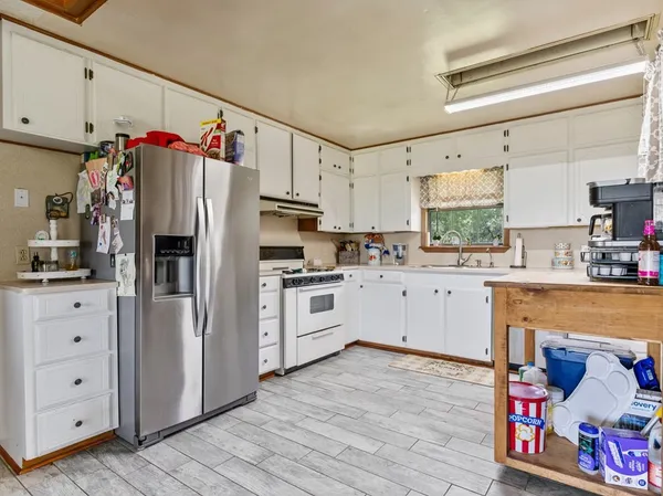 a kitchen with white cabinets and white appliances