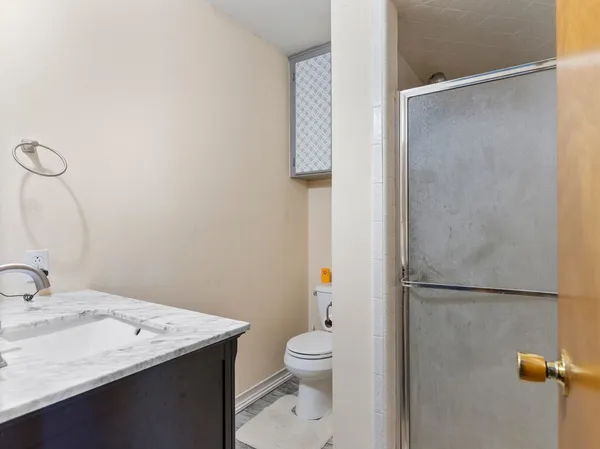 a bathroom with a granite countertop sink toilet and shower