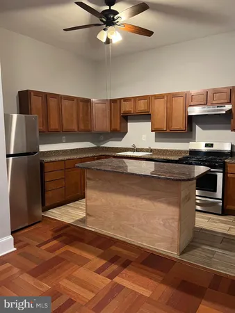 a kitchen with stainless steel appliances granite countertop a sink a stove top oven a counter space and cabinets