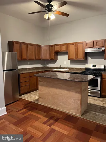 a kitchen with stainless steel appliances granite countertop a sink a stove top oven a counter space and cabinets