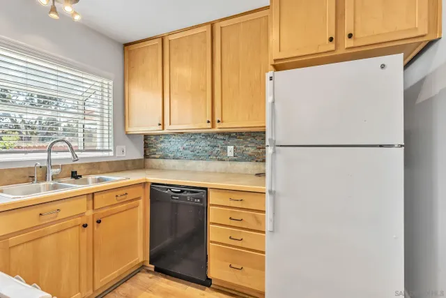 a kitchen with a refrigerator sink and cabinets