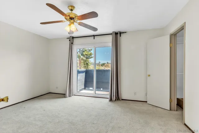 an empty room with a ceiling fan and a window