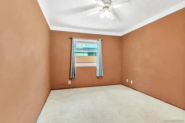 an empty room with a chandelier fan