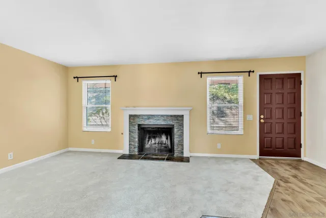 an empty room with a fireplace and window