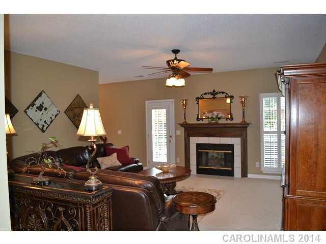 704 West Cheval Drive Fort Mill, SC 29708 - Photo 4 of 16 a living room with furniture a fireplace and a chandelier