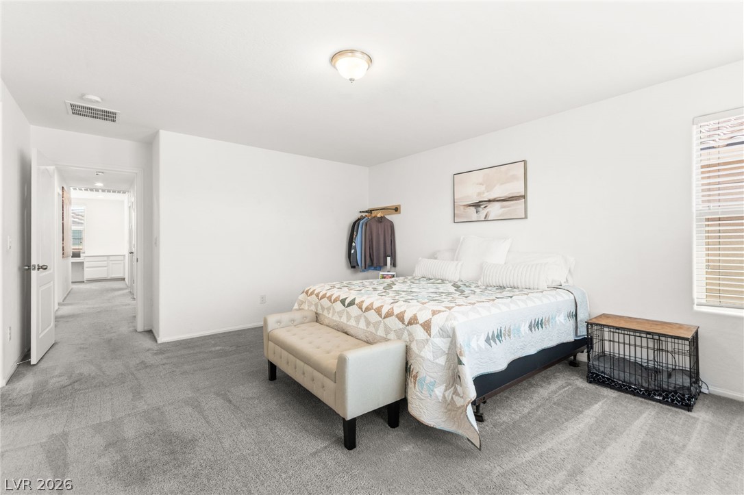 6435 Point Isabel Way Las Vegas, NV 89122 - Photo 25 of 57 A quiet retreat, this bedroom offers plush carpeting and a bright window with blinds.