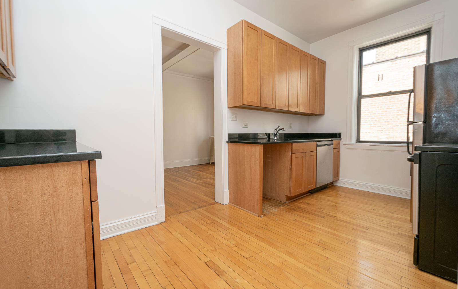 722 West Sheridan Road, Unit 3N Chicago, IL 60613 - Photo 8 of 14 a kitchen with granite countertop wooden cabinets and a stove