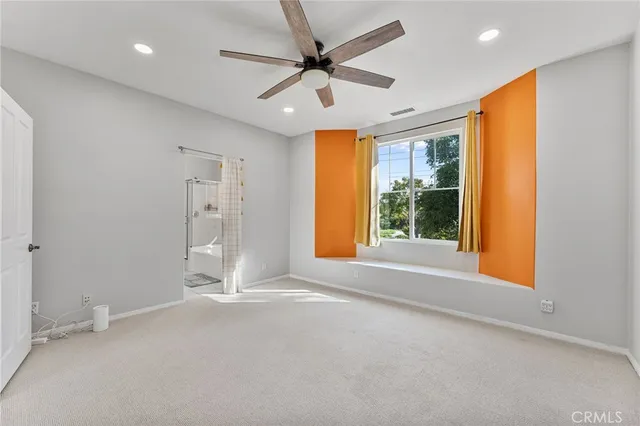 a view of an empty room with a window and a ceiling fan