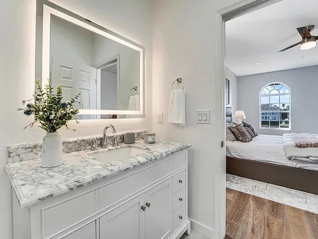 a bathroom with a granite countertop sink a mirror and a shower